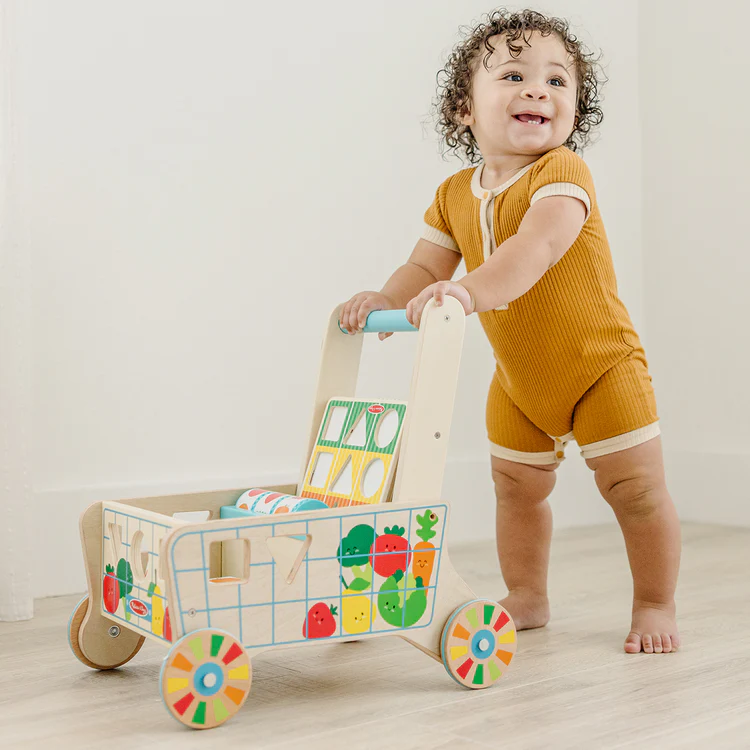Happy toddler playing with wooden toys in bright room